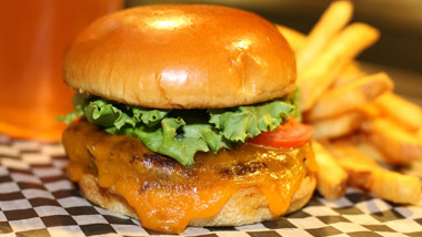 close up of cheeseburger, fries, and beer